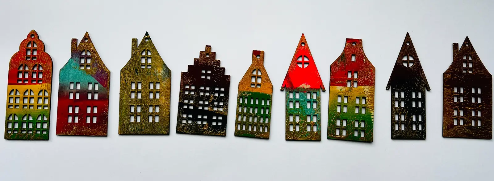 A row of colourful house-shaped wooden hanging ornaments.