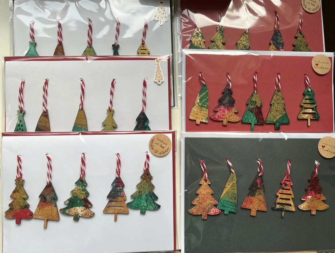 Handmade Christmas tree ornaments displayed on festive cards.